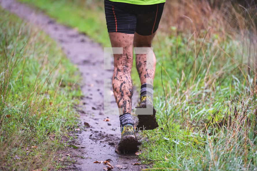 man running on a muddy trail 