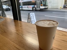 coffee cup on a table and view of a city bus 