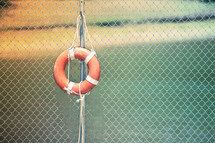 lifeguard float on a chain linked fence 