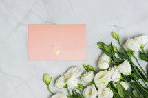 pink envelope and white roses 