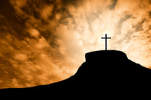silhouette of a cross on a mount at sunrise 