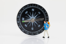 figurine in front of a compass 