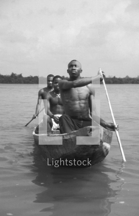 fishermen rowing a wood boat 