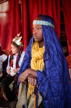 a boy child dressed as Joseph in a live nativity scene 