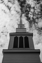 white church steeple in the clouds