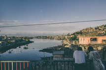 Two Hatian men talk on a bridge overlooking the city.