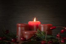 Lit advent candles in garland with berries