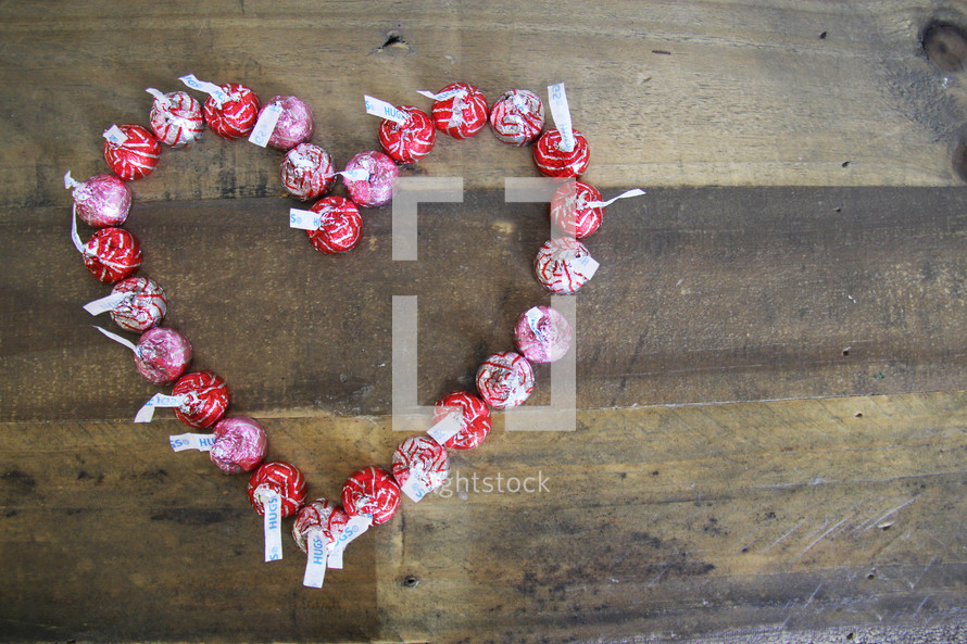 Hersey Kisses in a heart shape on a wood background 