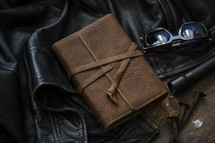 leather jacket, leather-bound Bible, and sunglasses 