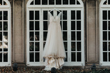 wedding dress hanging in a window 