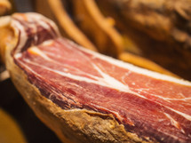Jamon serrano. Traditional Spanish ham in the market close up. Pork leg ham on table. 


