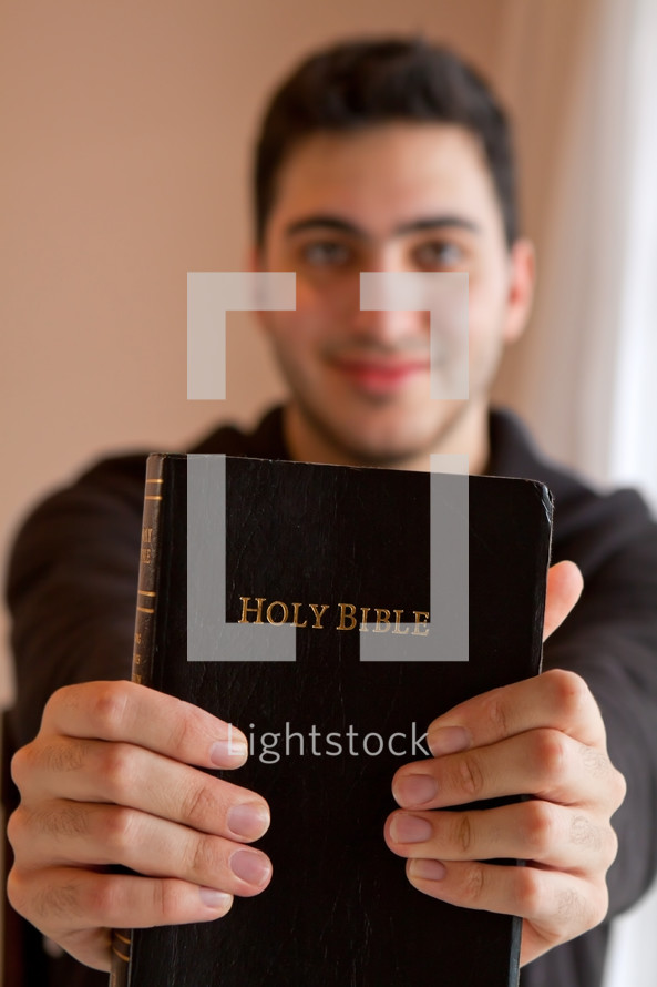 Man holding out a Holy Bible