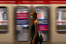 a woman wearing a face mask in a subway 