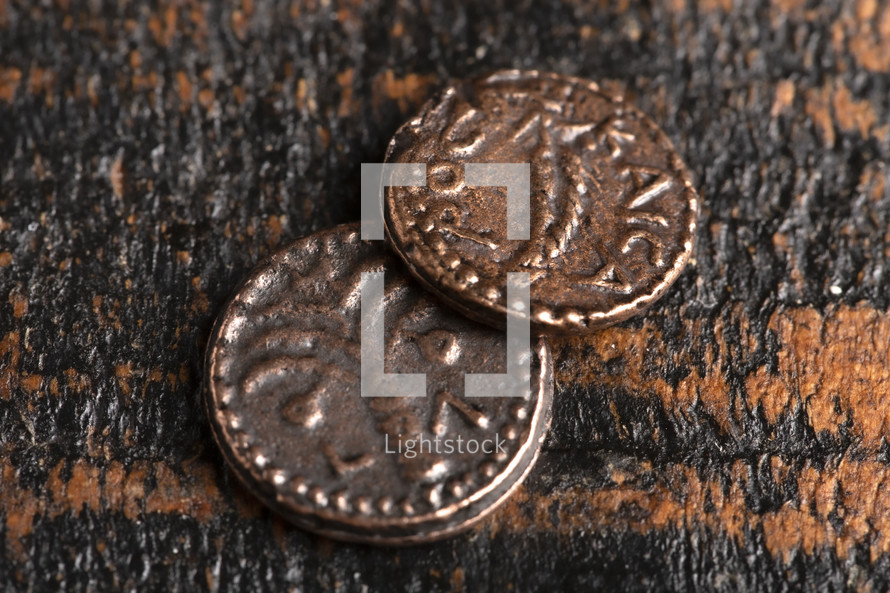 Two Small Copper Coins or Widows Mites Isolated on a Wood Background