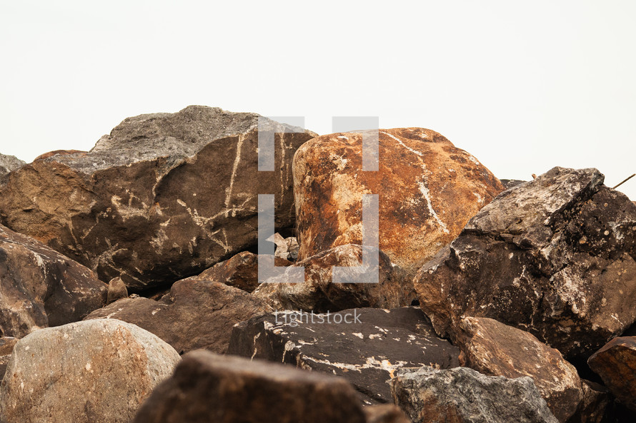 A pile of boulders against a white sky