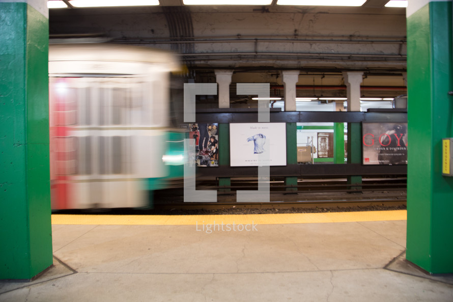 A subway train moving next to the subway platform.