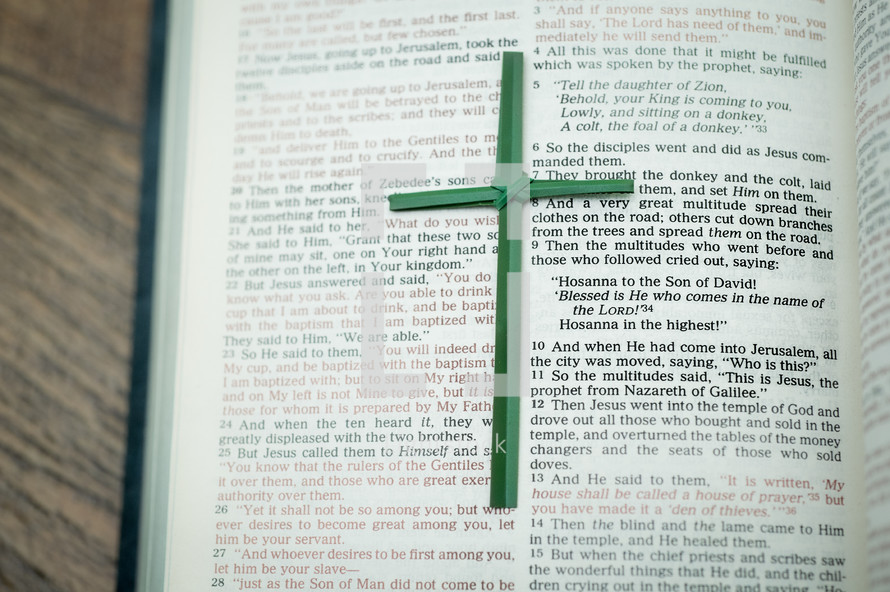 Flax cross on Bible open to Matthew 21.