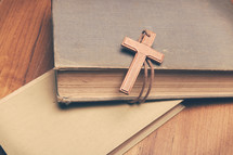 a wooden cross and books 