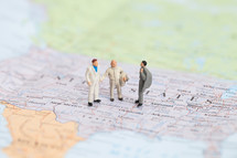 miniature figurines standing on a map of the United States 