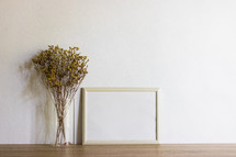 tall grasses in a vase and blank frame 