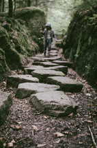 A girl walks along a stepping stone path