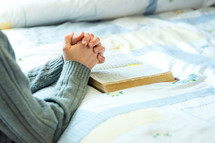 praying beside the bed with a bible