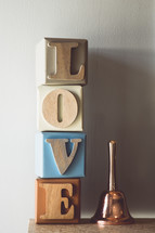 word love on wooden blocks and a hand bell 