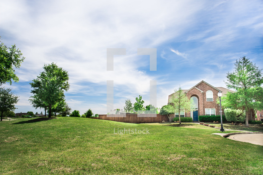 green grass in a front yard and brick house 