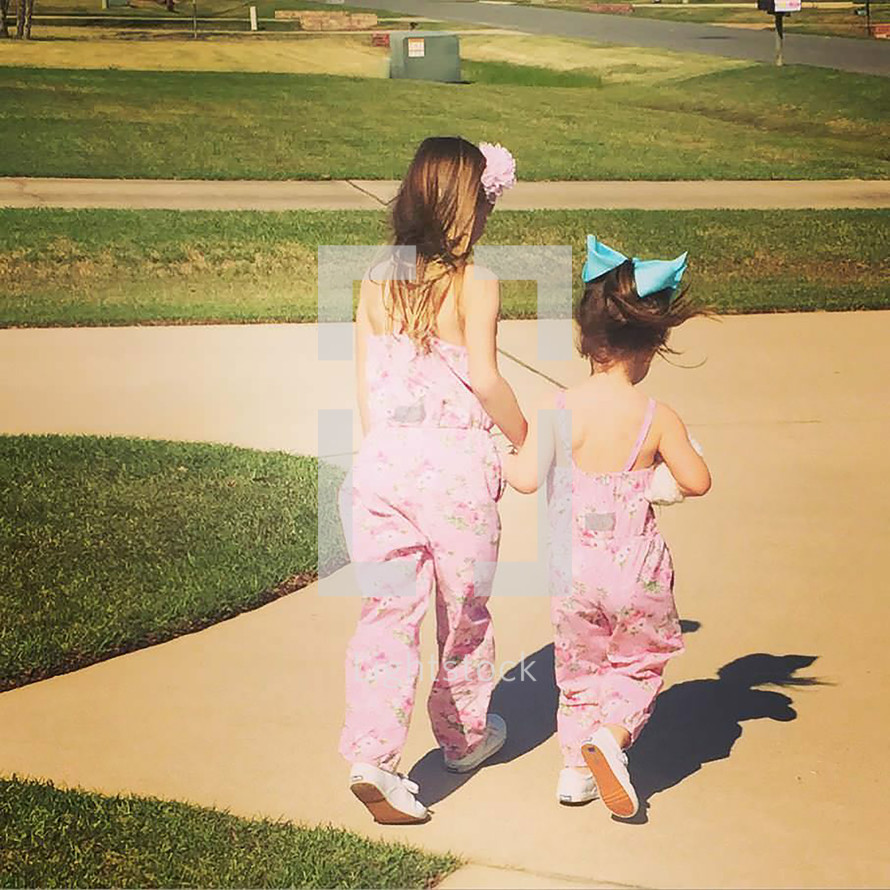 cousins in matching outfits walking holding hands 