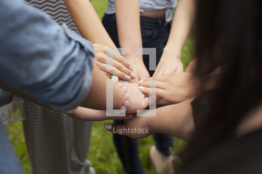 A group of girls are united as they put their hands together.