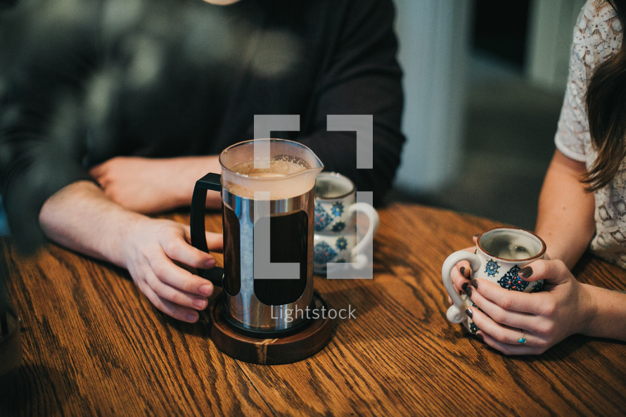 a couple sitting at a table having coffee 