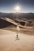 man standing in a desert with raised arms 