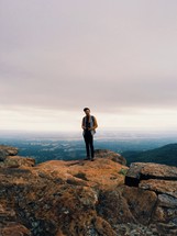 Man standing at the top of a mountain. 