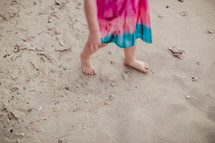 toddler girl walking in sand 
