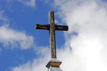 Rugged Cross on a Steeple - A large rugged cross atop a country church is highlighted against a summer sky.  The empty cross shows "He is risen!"