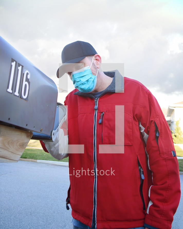 a man wearing a mask checking the mail 