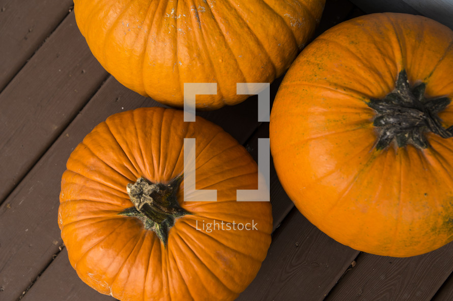 three pumpkin on a porch 