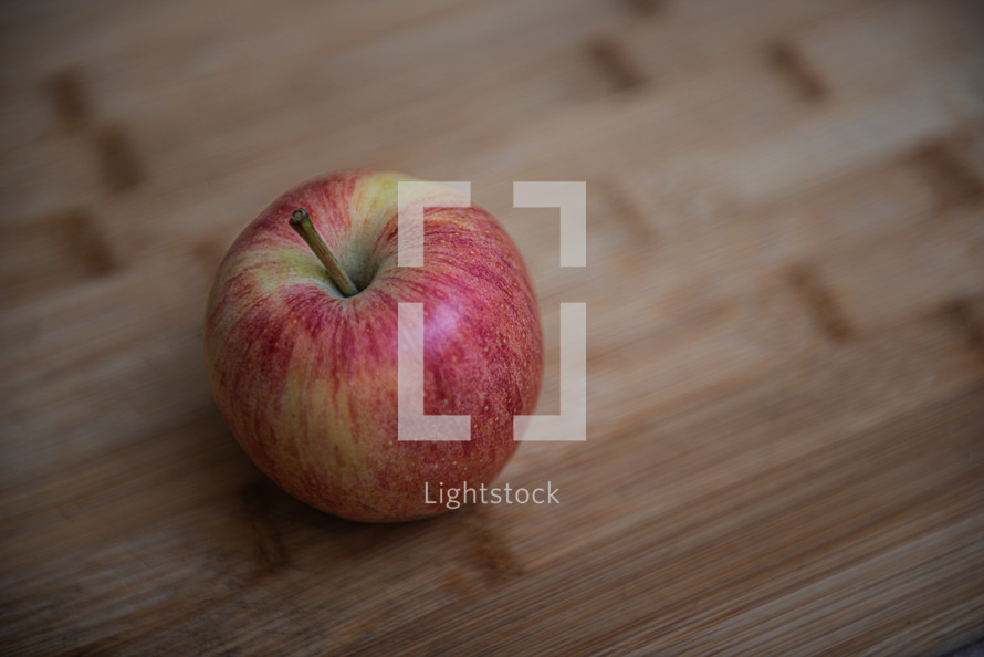 top view of one rustic apple on a wooden background