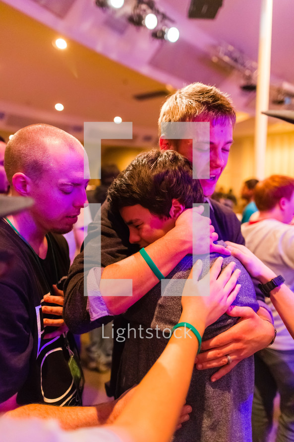 Man embracing young man, boy crying, prayer, love, healing