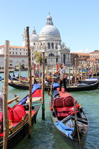 Gondolas await passengers in the Grand Canal. In the background the church of Santa Maria della Salute.