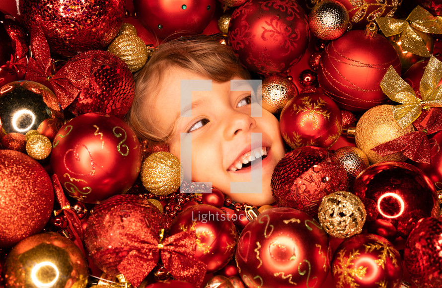 Toddler boys face lights up with joy in Christmas tree toys balls. Wonder, happiness mood. Touch of magic Holiday-themed projects, family-focused content or sentimental storytelling.