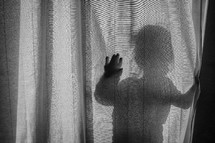 shadow of a toddler behind a curtain 