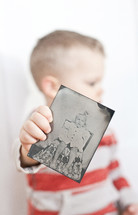 toddler boy holding an old photo