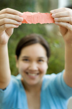 A woman holding up a scrap piece of paper 