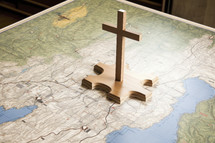 Missionary work. Wooden cross on the map of the world