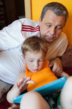 Grandfather and grandson with touch pad