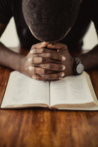 man praying over a Bible