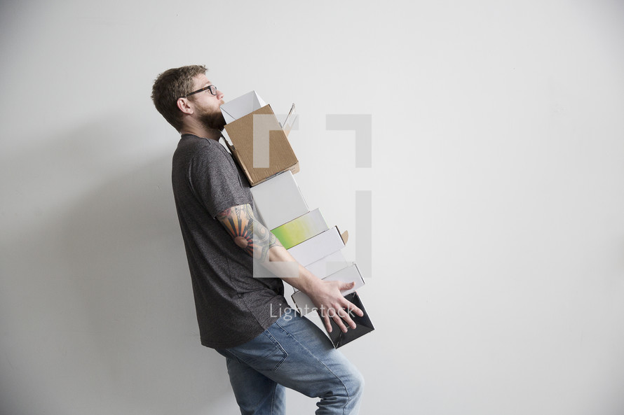 a man carrying a stack of boxes 