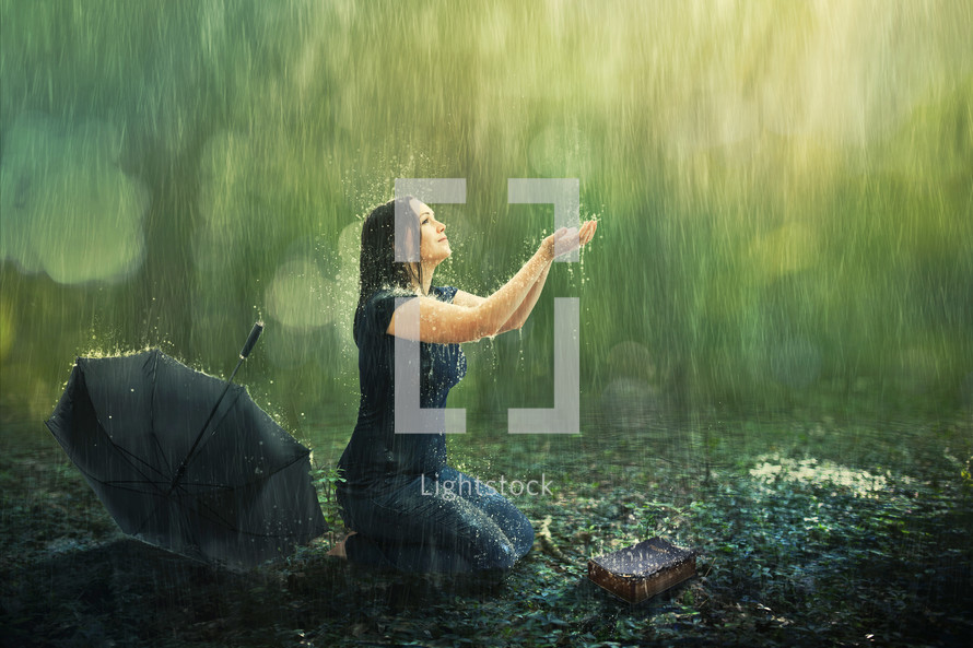 a woman kneeling in rain 