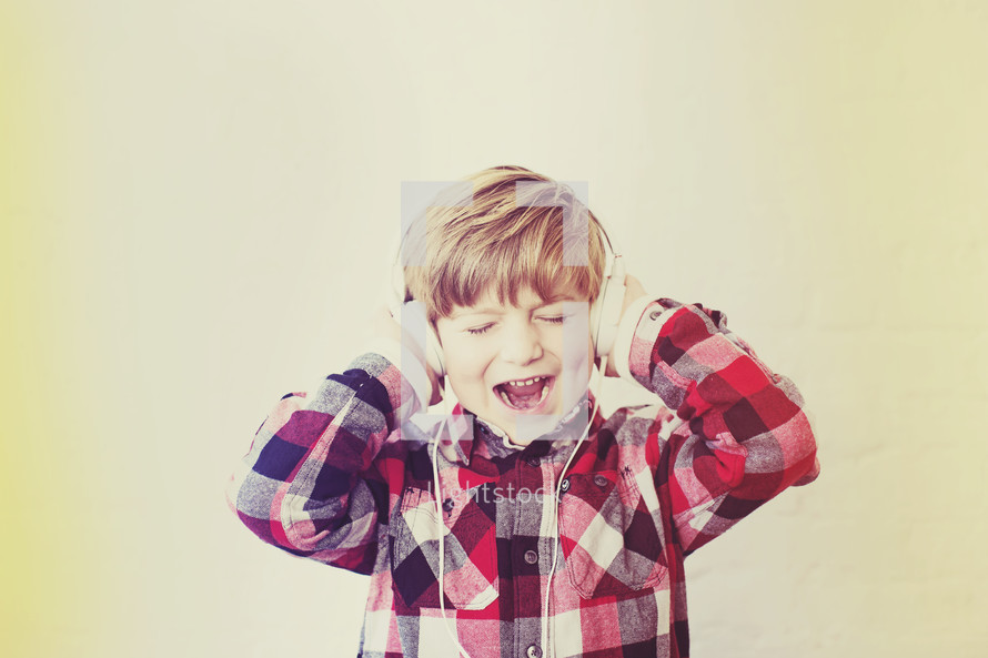a boy child wearing headphones and singing